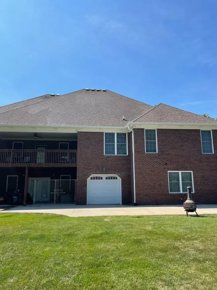 A large brick house with a white garage door and a fire pit in front of it.