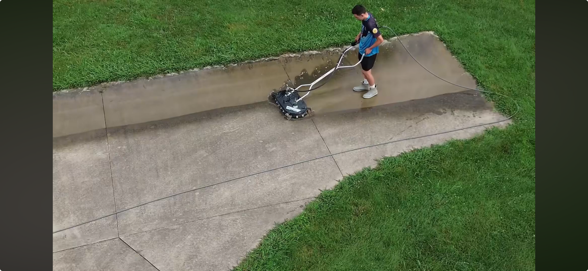 Man pressure washing a driveway with a surface cleaner. The Clean Home Exterior Cleaning logo is at the bottom of the image.
