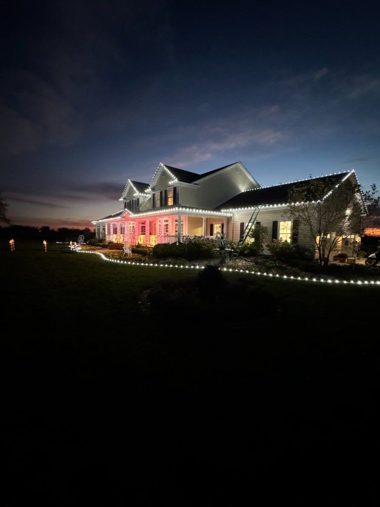 A large house is lit up with christmas lights at night