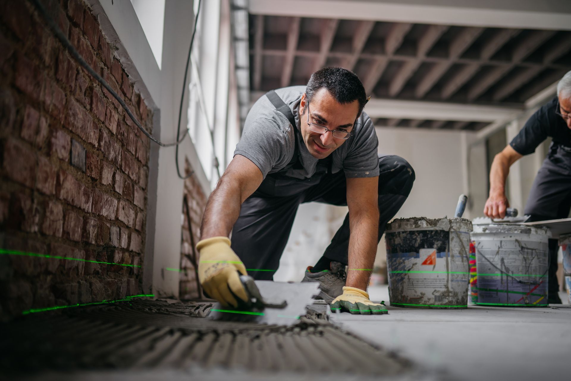 Commercial concrete contractor smoothing floor surface inside a modern building under renovation.