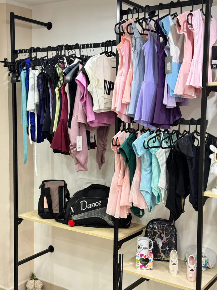 Espositore per abiti da ballo in un negozio. Sono visibili abiti, body e borse.