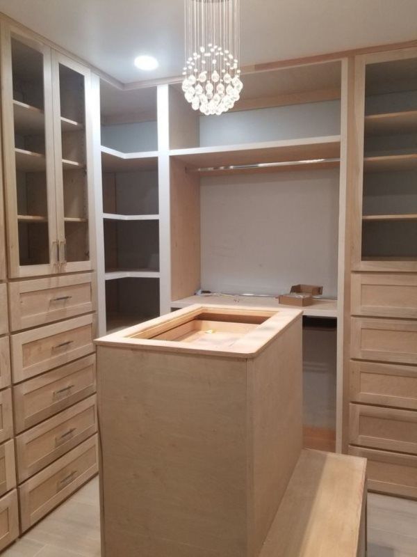 A walk in closet with lots of drawers and shelves