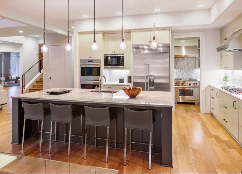 A kitchen with stainless steel appliances and a large island.