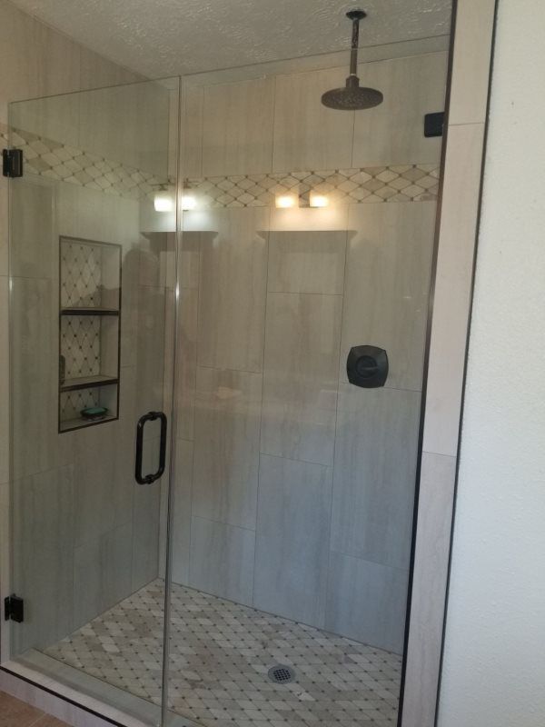 A shower with a glass door and a ceiling shower head