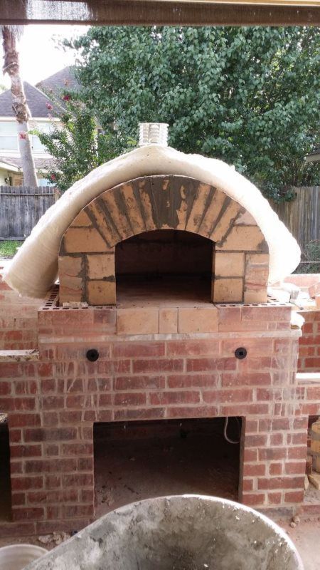 A brick oven is being built in a backyard.