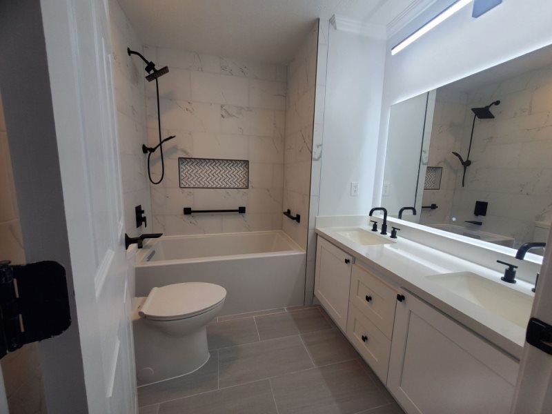 A bathroom with a toilet , sink , bathtub and mirror.