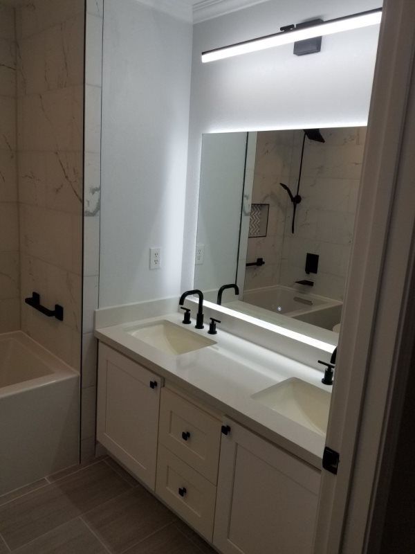 A bathroom with two sinks and a large mirror