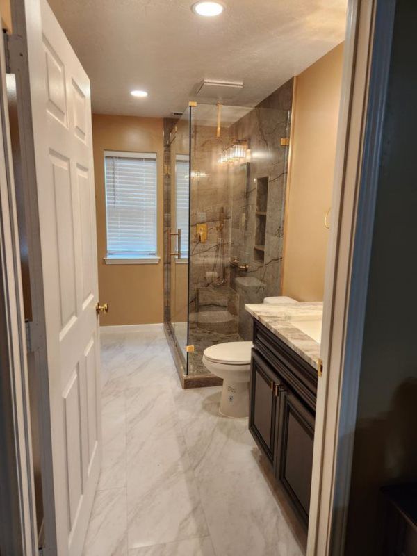 A bathroom with a toilet , sink , and shower.