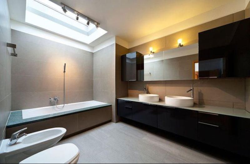 A bathroom with two sinks , a toilet and a bathtub.