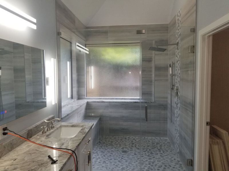 A bathroom with a sink , shower , and mirror.