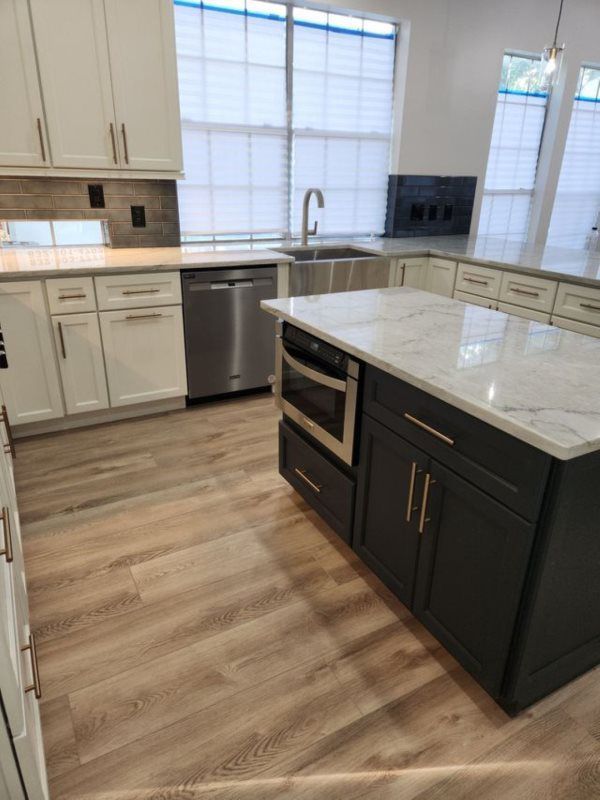 A kitchen with a large island and marble counter tops