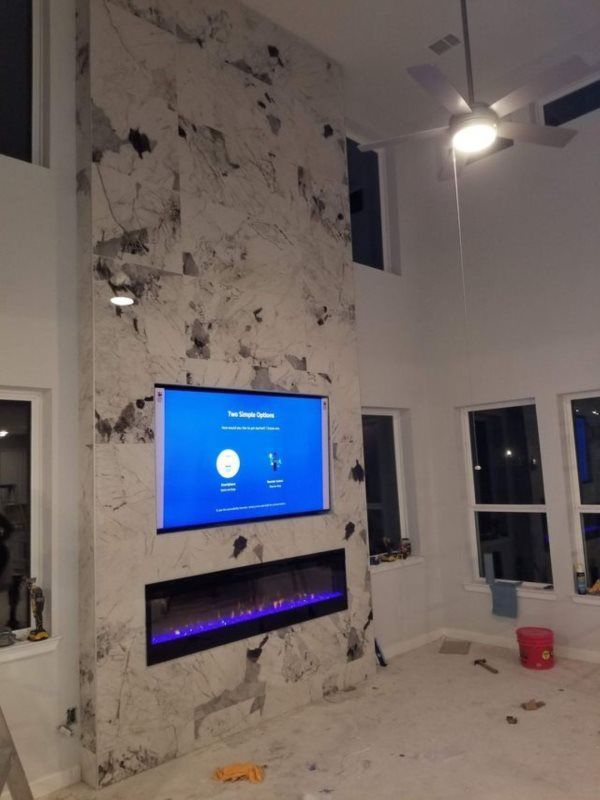 A living room with a fireplace and a flat screen tv