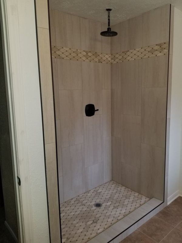 A walk in shower with a ceiling shower head