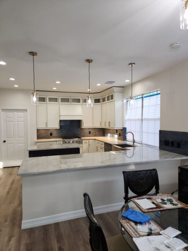 A kitchen with white cabinets and granite counter tops is being remodeled.