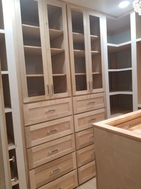 A walk in closet with lots of drawers and shelves