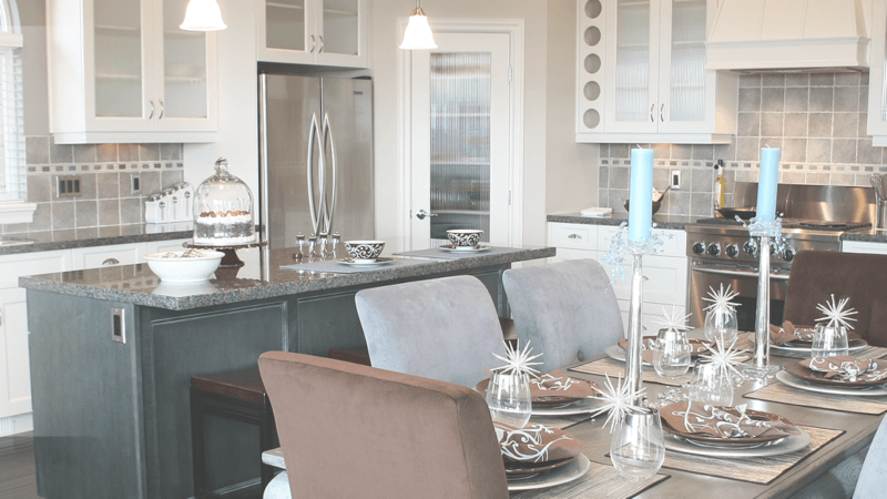 A kitchen and dining room with a table and chairs set for a meal.