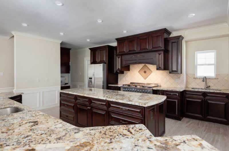 A kitchen with granite counter tops and wooden cabinets.