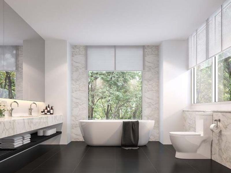 A bathroom with a tub , toilet , sink and mirror.