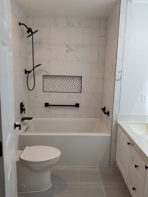 A bathroom with a toilet , bathtub and shower