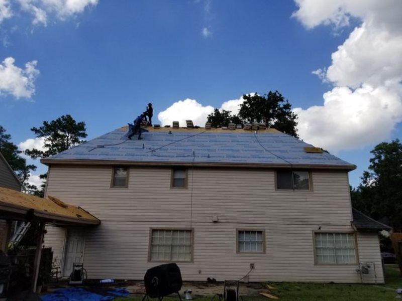 A man is working on the roof of a house.