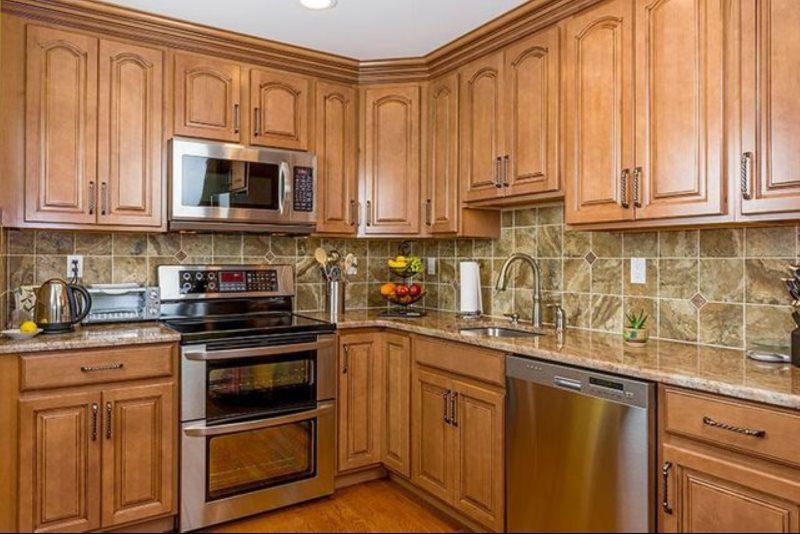 A kitchen with wooden cabinets and stainless steel appliances.