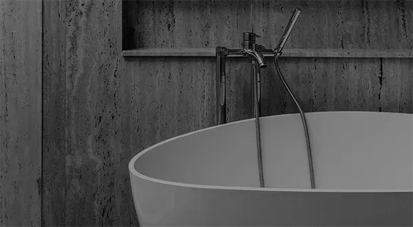 Ein Schwarzweißfoto einer Badewanne in einem Badezimmer.