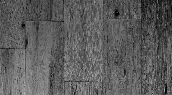 Ein Schwarzweißfoto eines Holzbodens.