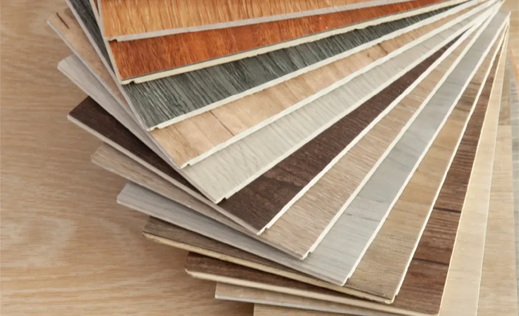 Ein Stapel verschiedener Holzbodenmuster auf einem Holztisch.