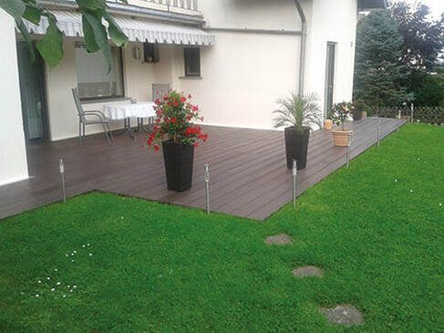 Decking Millhouses brown plastic decking going from house to lawn