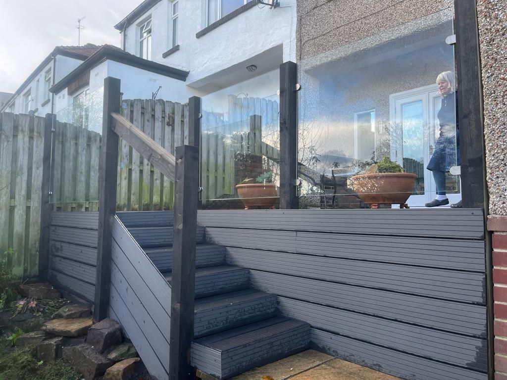 Decking Sheffield raised decking ideas with glass balustrade along stairway