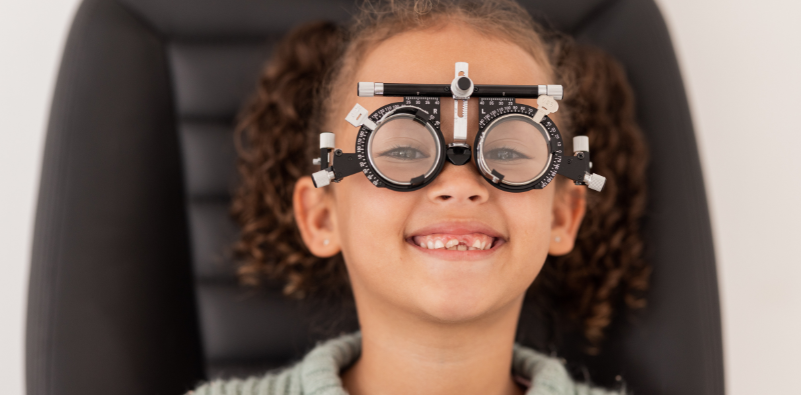 A child wearing a trial frame at an eye test