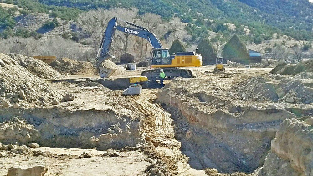 Excavator moving dirt at build location
