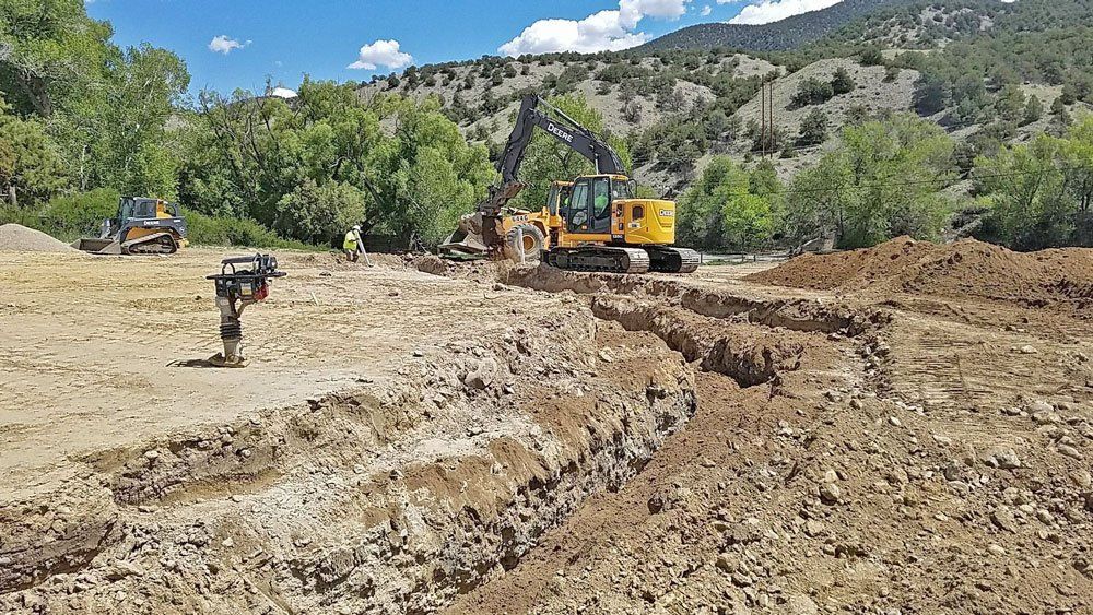 Excavator digging a trench for pipe.