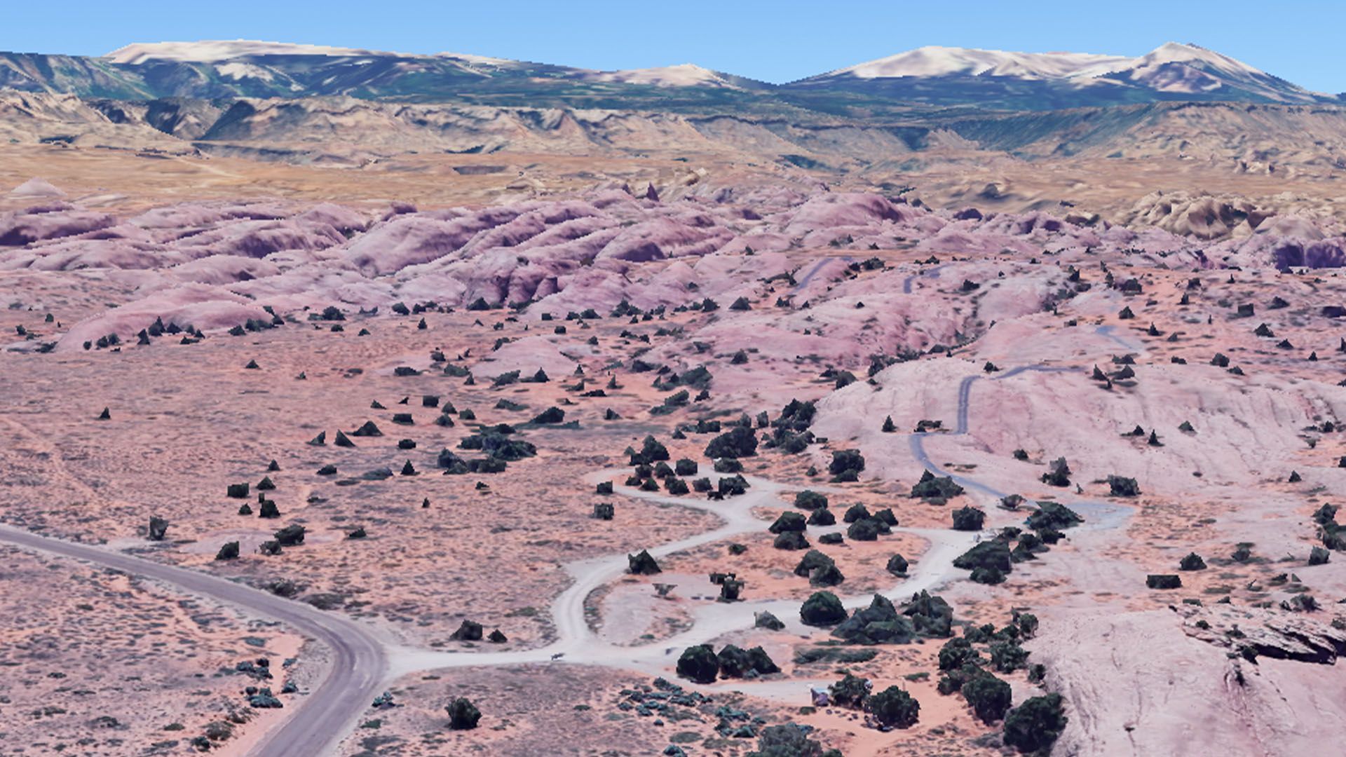 Arid desert landscape with pink sandstone formations.