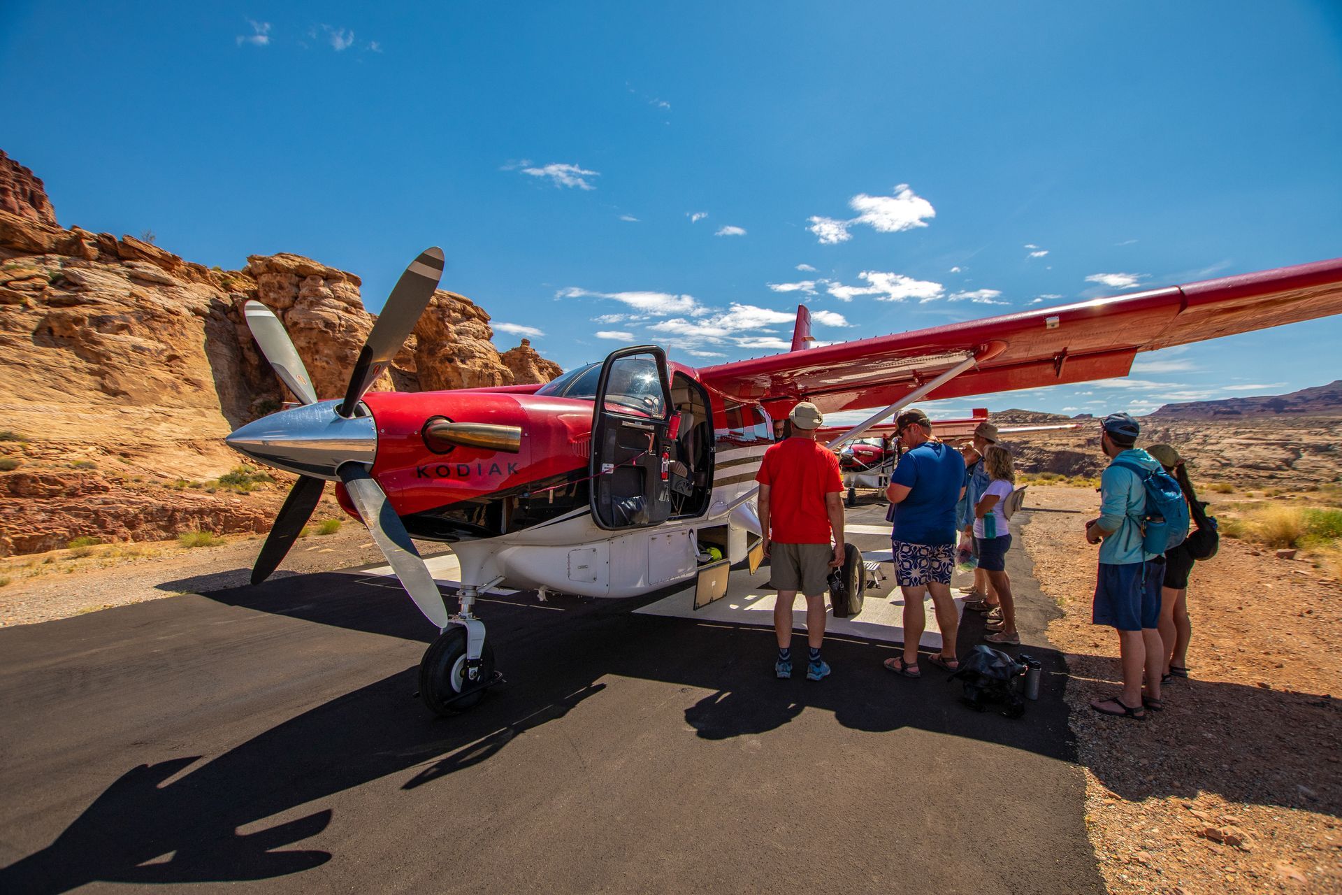 A plane on a runway in Moab loading passengers for an airplane tour.