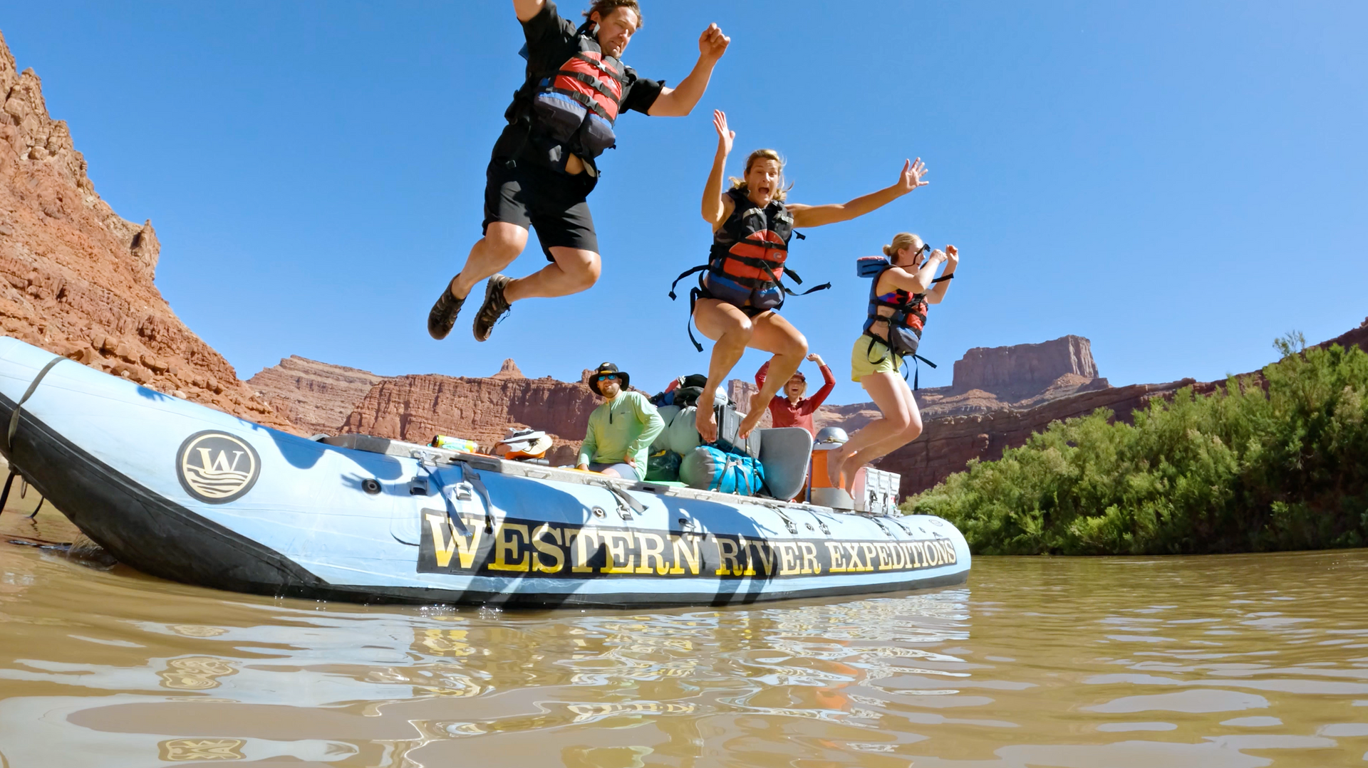A family jumps off a raft in Desolation Canyon