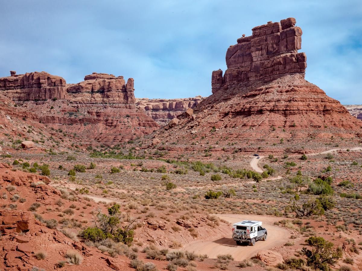 A truck with a camper and a mountain bike exploring Moab