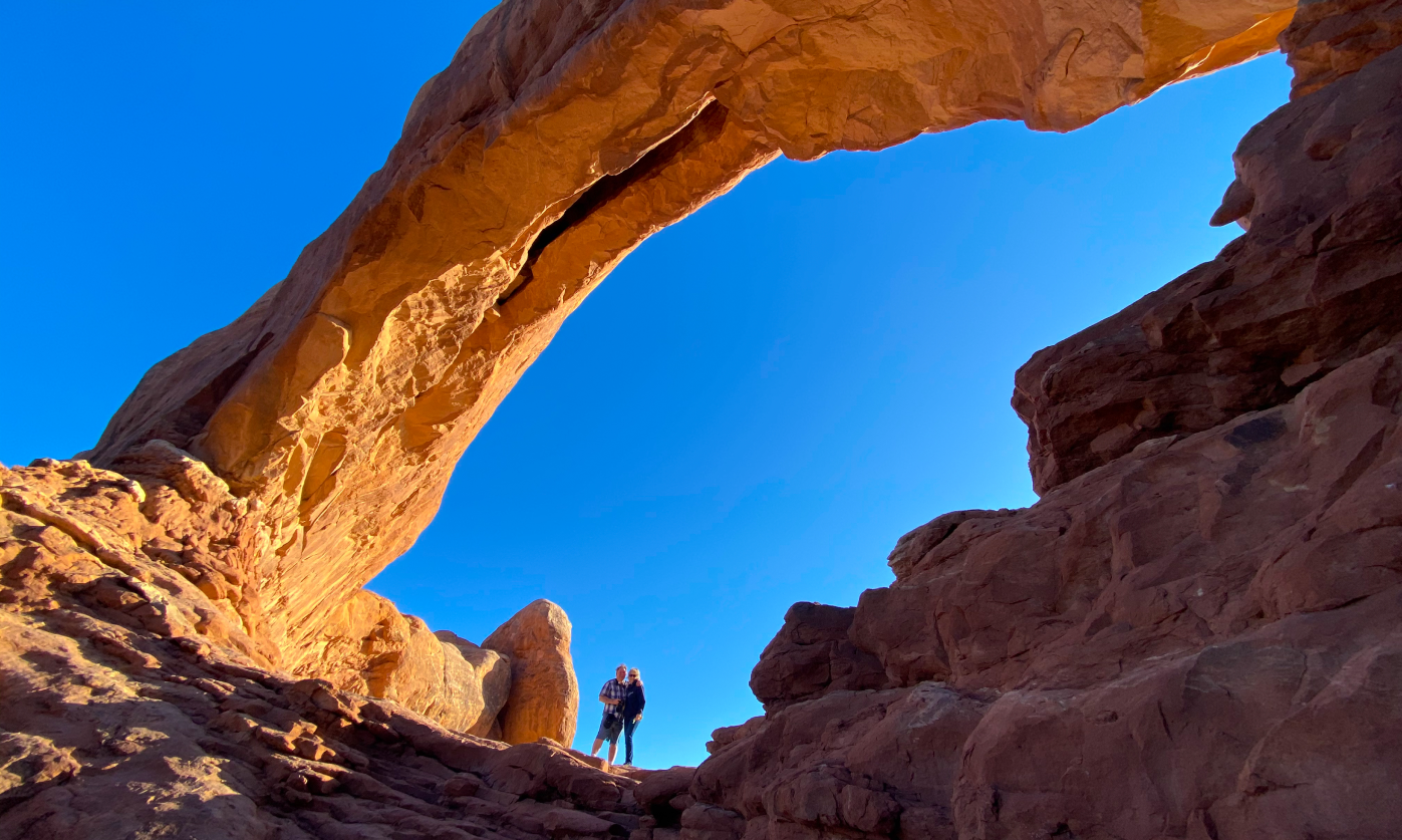 A couple standing under Corona Arch