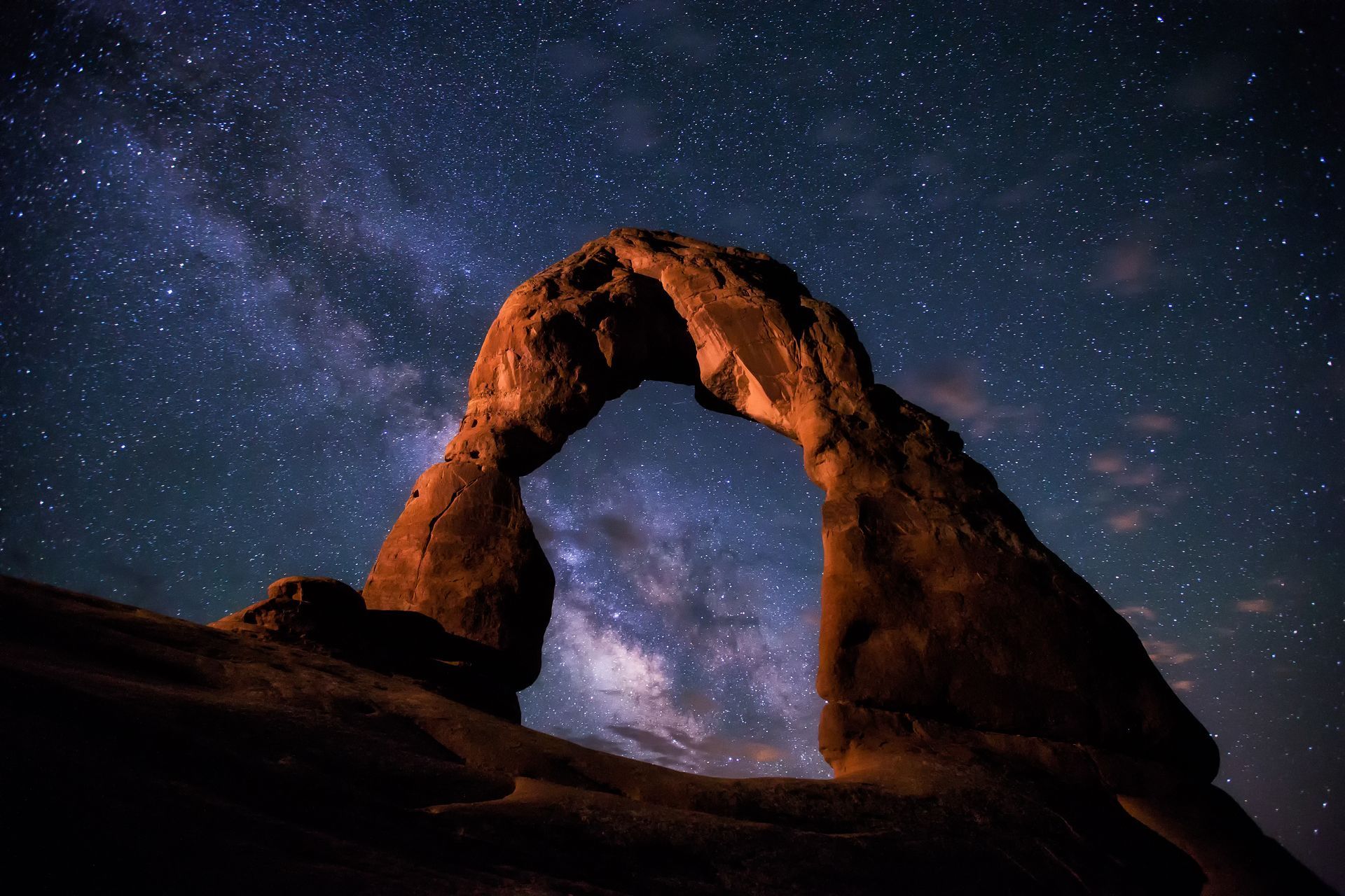 Delicate Arch at night with a star-filled sky in the background.