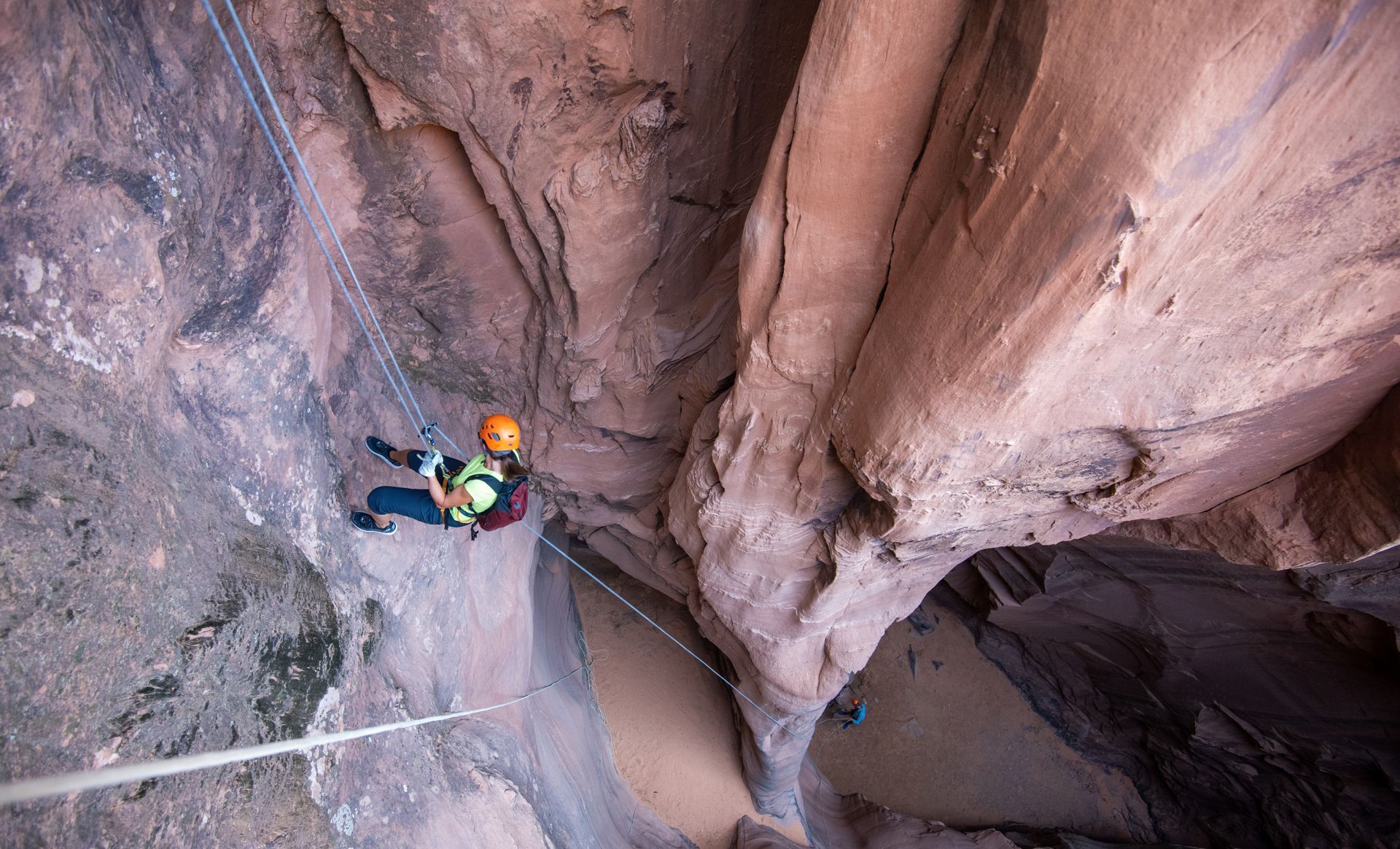 A person is canyoneering into a narrow canyon.