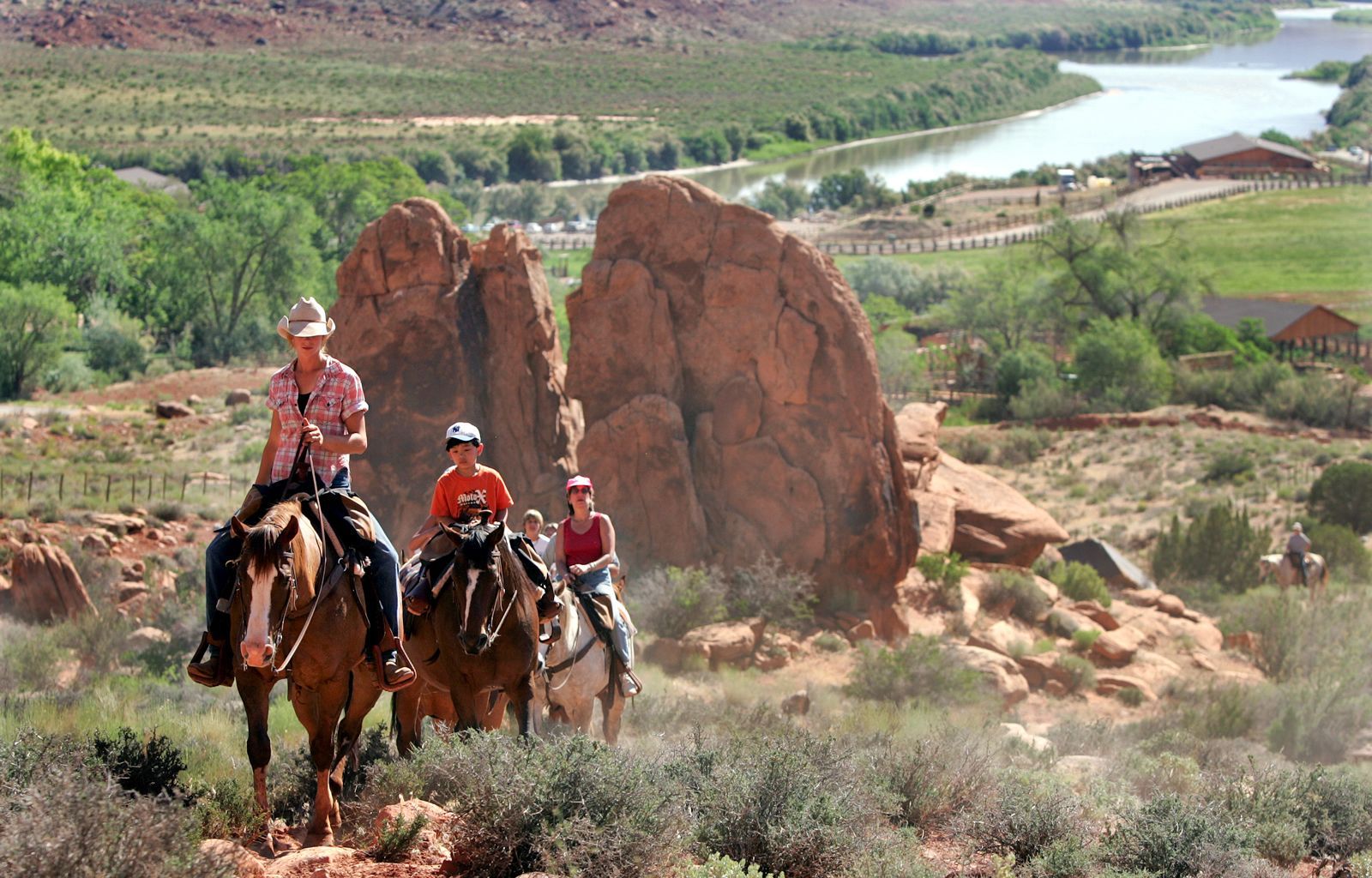 A group of people are riding horses in the desert.