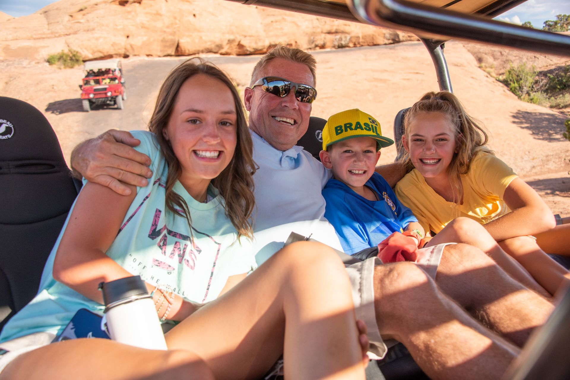 A family hugging each other in the back of a Hummer vehicle.