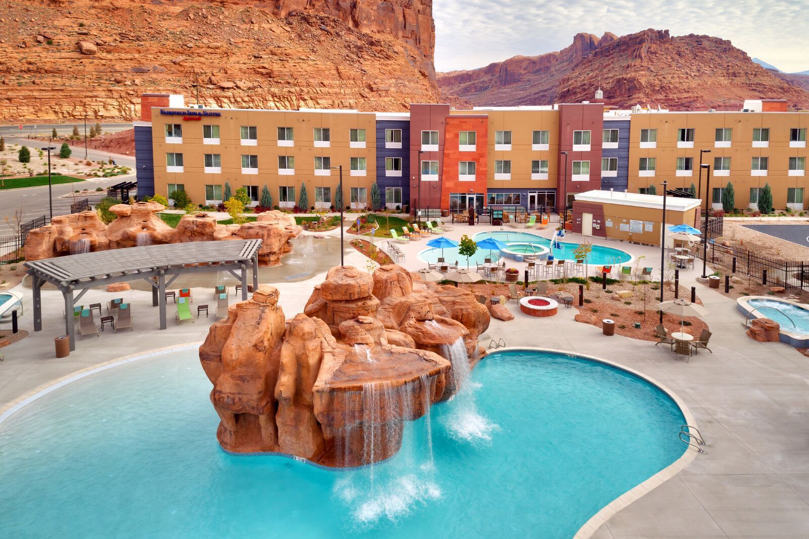 Hotel with outdoor pools, water features, and red rock mountain backdrop.