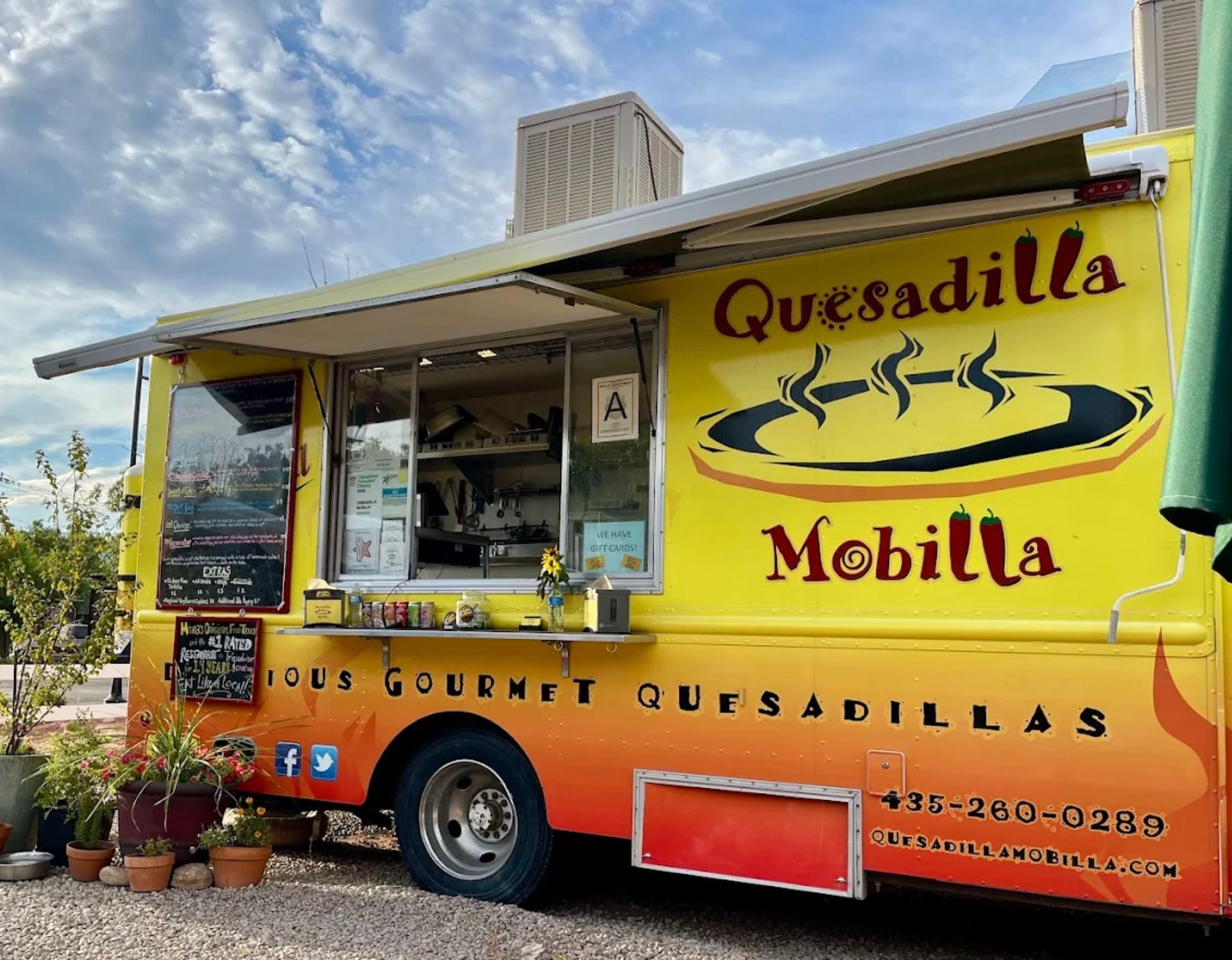 Quesadilla Mobilla food truck with menu and open window.