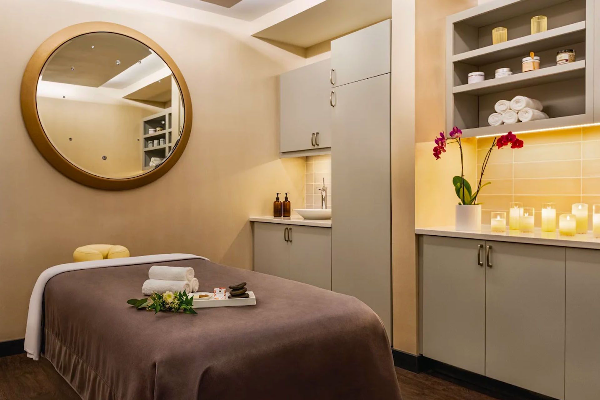 Spa Moab interior with massage table and candles and a large wall mirror.