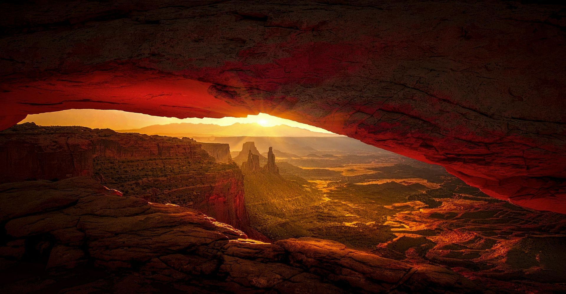 The sun rising through the Landscape Arch in Canyonlands National Park, located in Moab, Utah.