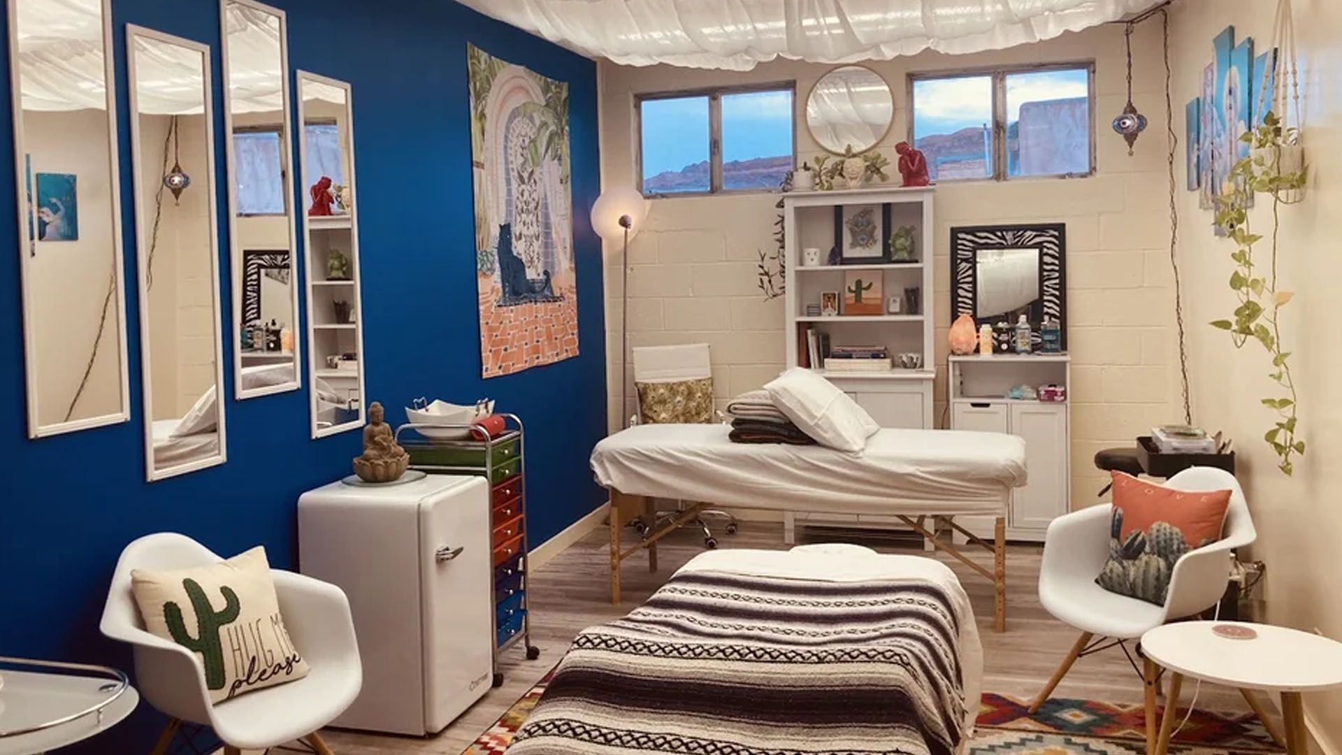 inside view of the Prickly Pear Massage Studio with 2 massage beds, windows and chairs.