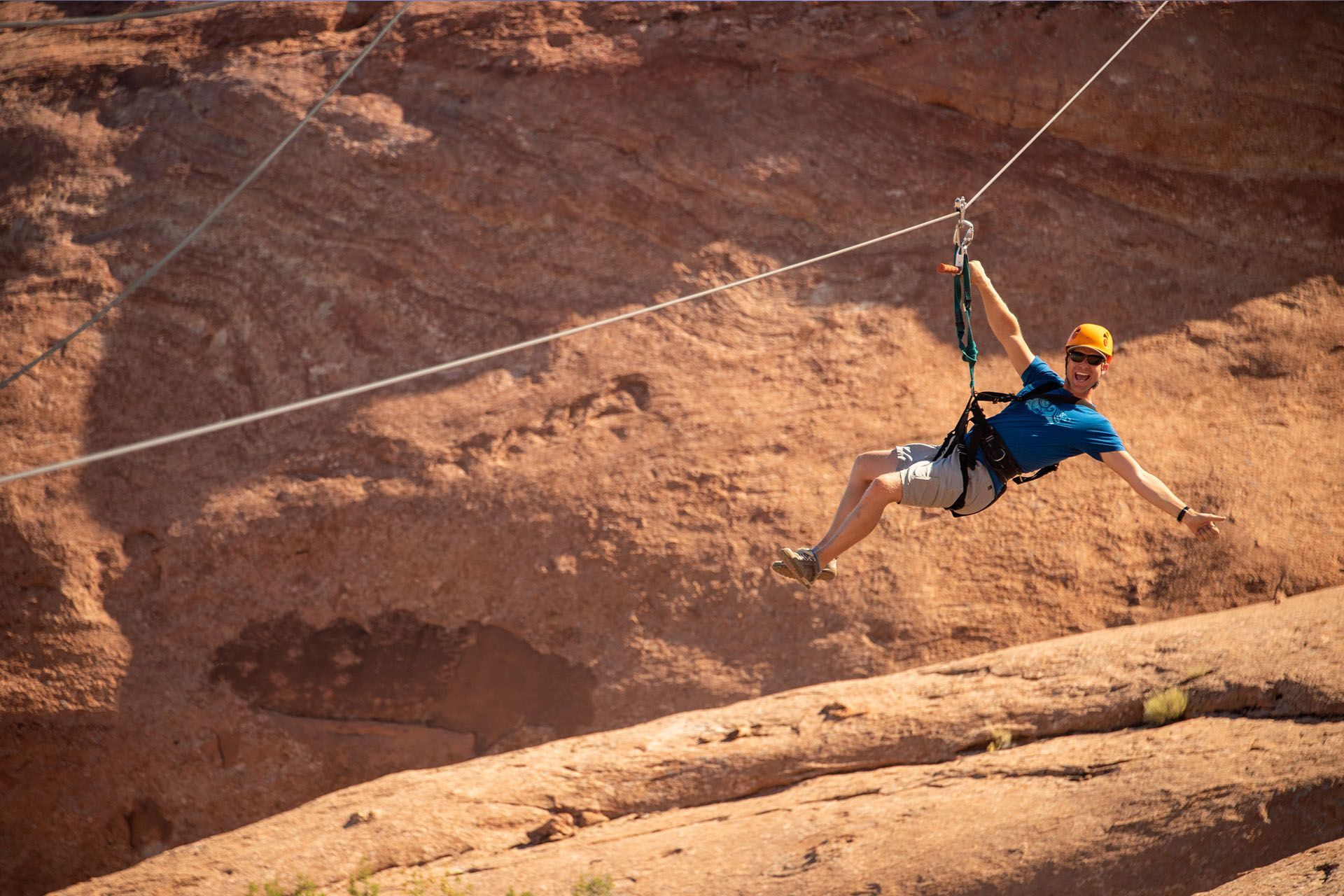 A man zips down a zipline in Moab