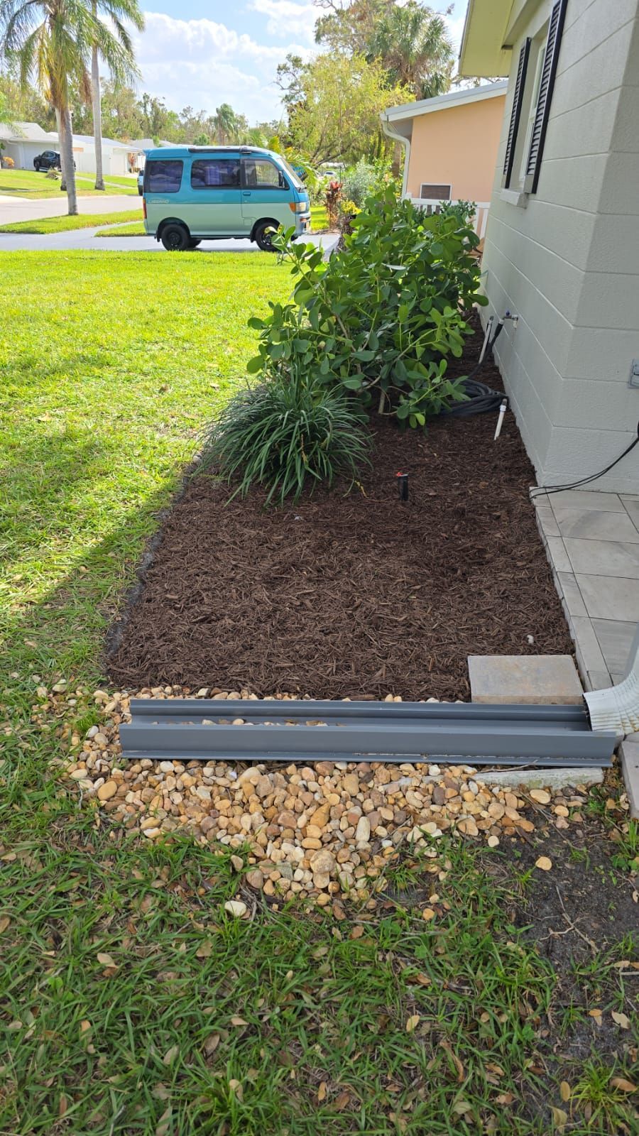 a stone bench is sitting on top of a stone walkway in a garden .