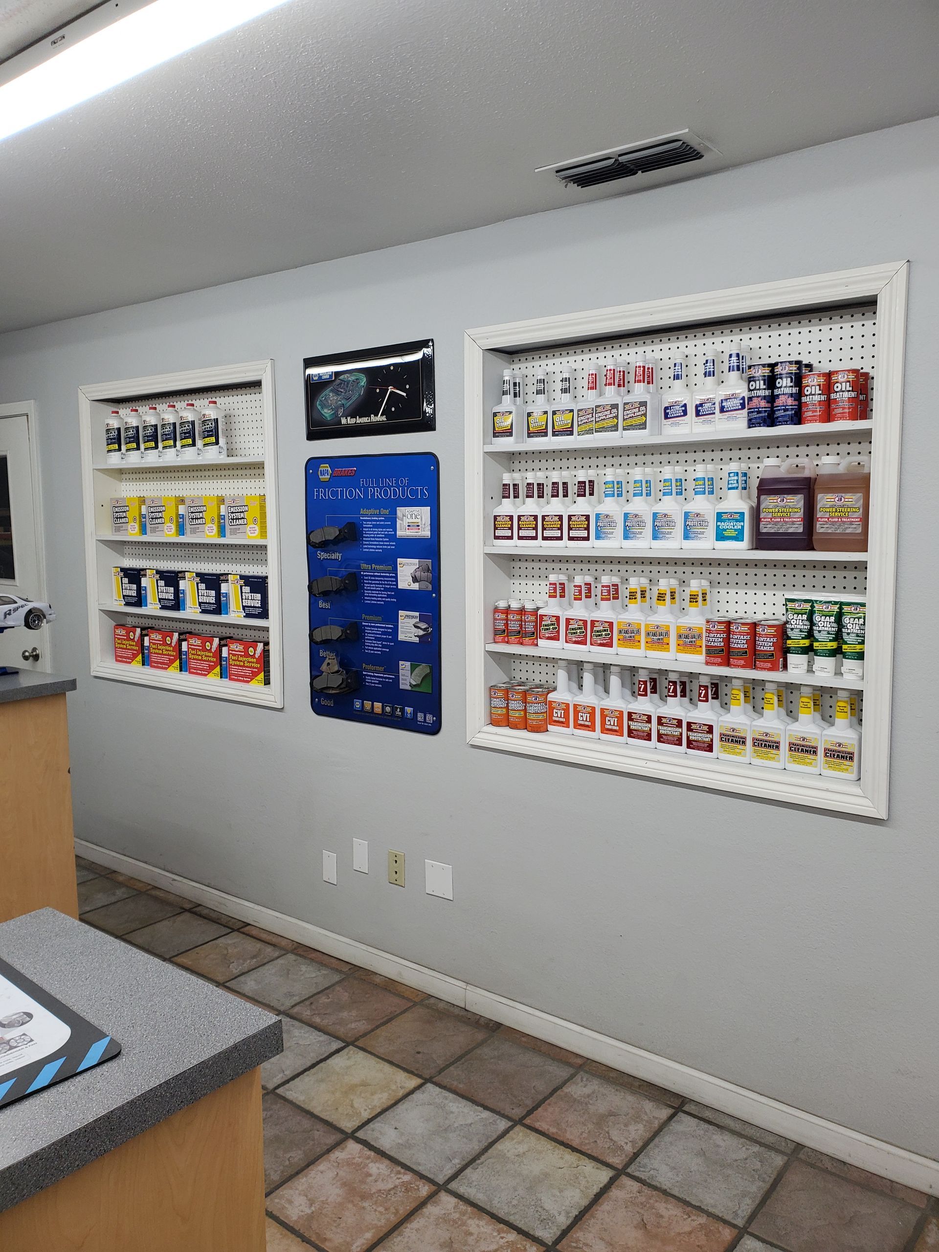 Interior of a store showcasing shelves of paint cans and product displays on a gray wall. | Hal's Auto Care